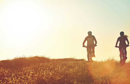 Adventure lies around every corner. a pair of adventurous mountain bikers out on a trail on a sunny day