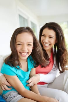 A fun day with mom. A mother tickling her daugher while her daughter laughs in a moment of bonding