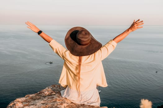 Portrait of happy young woman wearing summer black hat with large brim at beach on sunset. Closeup face of attractive girl with black straw hat. Happy young woman smiling and looking at camera at sea