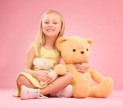 Teddy bears, girl and portrait with soft toys with happiness and love for playing in a studio. Isolated, pink background and a young female child feeling happy, joy and cheerful with stuffed friend.