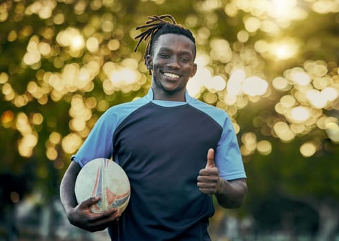 Rugby, thumbs up and portrait of black man with ball, confidence and pride in winning game. Fitness, sports and happy face of player ready for match, workout or competition at stadium in South Africa.