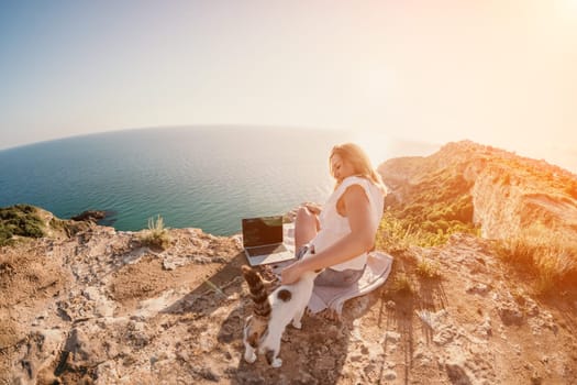 Woman sea laptop. Business woman in yellow hat working on laptop by sea. Close up on hands of pretty lady typing on computer outdoors summer day. Freelance, digital nomad, travel and holidays concept.