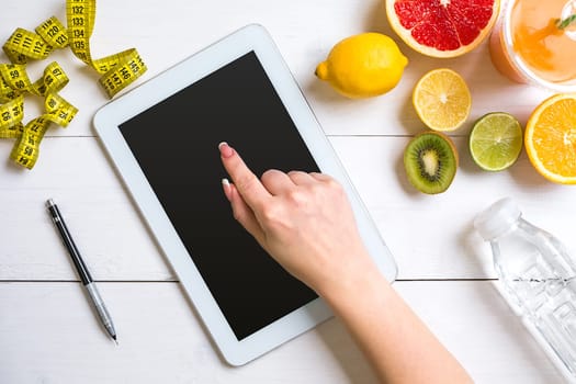 Fresh fruits with tape measure over white wooden background. Fitness concept. Top view. Copy space Flat lay