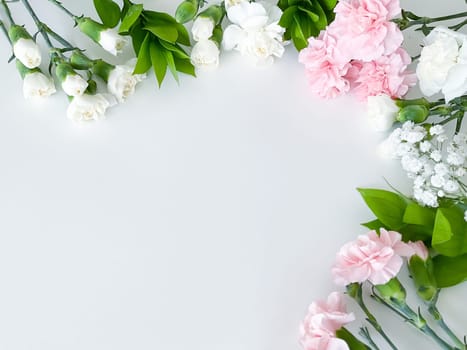 Close up photo of a bouquet of pink and white carnations isolated on a white background. With empty space for text or inscription. For postcard, advertisement or website.