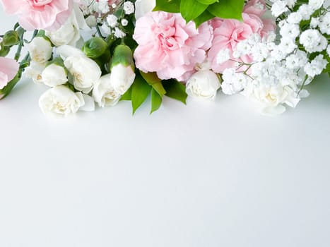 Close up photo of a bouquet of pink and white carnations isolated on a white background. With empty space for text or inscription. For postcard, advertisement or website.