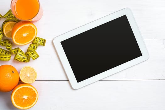 Fresh fruits with tape measure over white wooden background. Fitness concept. Top view. Copy space Flat lay
