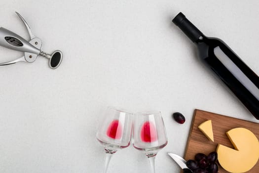 Wine, glasses and corkscrew over white background. Top view with copy space