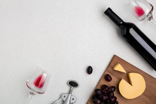 Wine, glasses and corkscrew over white background. Top view with copy space
