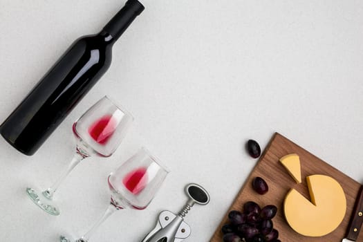 Wine, glasses and corkscrew over white background. Top view with copy space