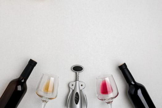Two wine glasses with red and white wine, bottles of red wine and white wine, corkscrew on white background. Horizontal view from the top. Mock-up. Copy space. Flat lay
