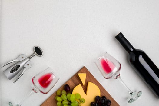 Wine, glasses and corkscrew over white background. Top view with copy space
