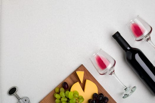 Wine, glasses and corkscrew over white background. Top view with copy space