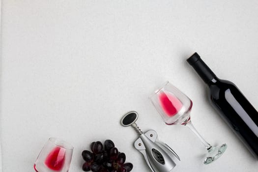 Wine, glasses and corkscrew over white background. Top view with copy space
