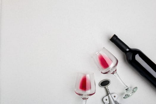 Wine, glasses and corkscrew over white background. Top view with copy space