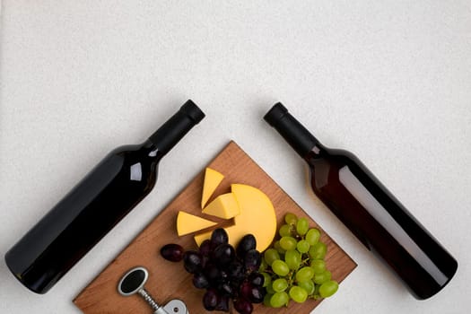 Bottles of red and white wine on white background from top view. Copy space