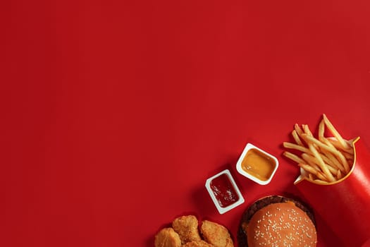 Concept of mock up burger, potatoes, sauce on red background. Copy space for text and logo. Flat lay