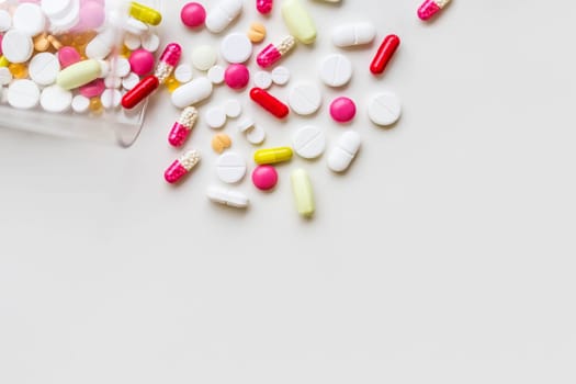 Pile of colorful medicine pills, white, blue, yellow and red, sitting on white background