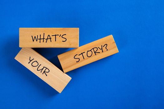 What's Your Story word on wooden block on blue background