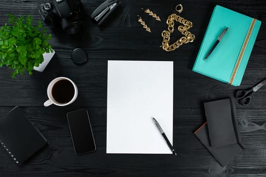 Flat lay, top view office table desk frame. Workspace with clean sheet of paper, mint diary and mobile device on dark background. Copy space
