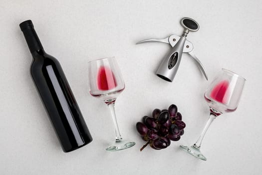 Wine, glasses and corkscrew over white background. Top view with copy space