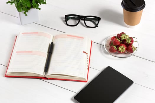 Stylish minimalistic workplace with tablet and notebook and glasses in flat lay style. White background. Top view. Copy space