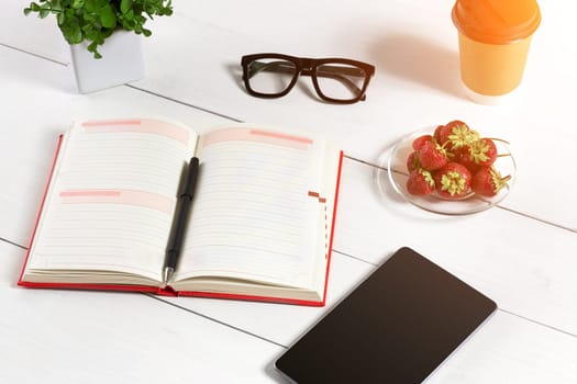 Stylish minimalistic workplace with tablet and notebook and glasses in flat lay style. White background. Top view. Copy space. sun flare