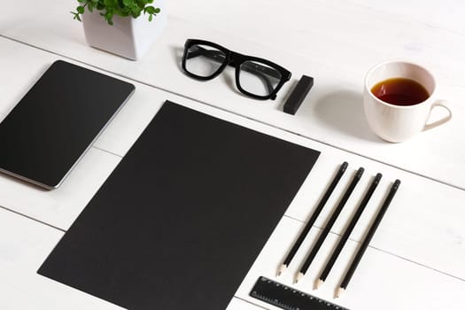 Modern workplace with digital tablet computer and mobile phone, cup of coffee, pen and empty sheet of paper. Top view and copy space for text