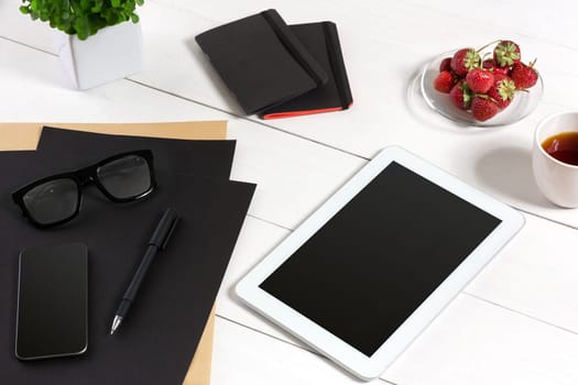 Modern workplace with digital tablet computer and mobile phone, cup of coffee, pen and empty sheet of paper. Top view and copy space for text