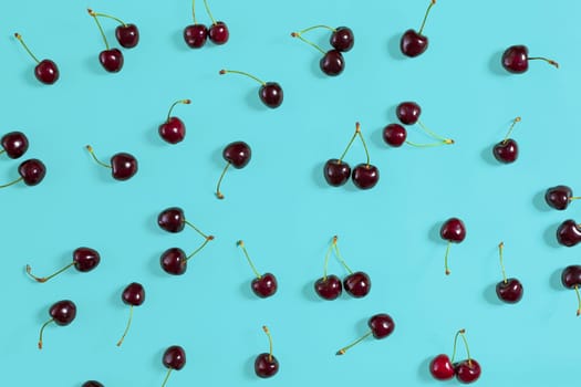 Fresh juicy cherries on mint background, top view. Copy space. Still life mockup flat lay