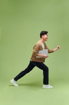 Full length image of young Asian businessman on blue background