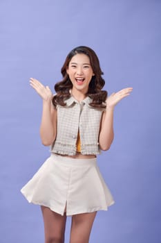 Portrait of beautiful young asian woman surprised and shocked on purple background