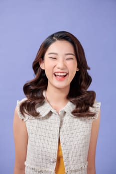 Portrait of happy and positive woman close eyes, smiling carefree, standing on purple background.