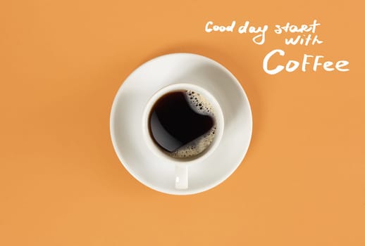 Top view of cup of black coffee and Good day start with Coffee lettering isolated on orange background. Still life. Mock up. Flat lay