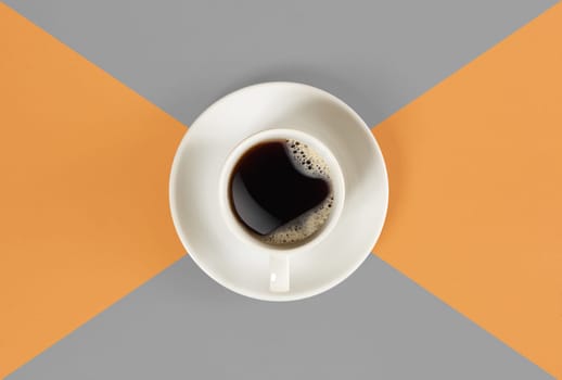 A cup of black coffee on orange and gray background. View from above. Still life. Mock up. Flat lay. Copy space