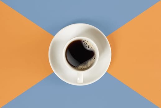 A cup of black coffee on orange and blue background. View from above. Still life. Mock up. Flat lay. Copy space