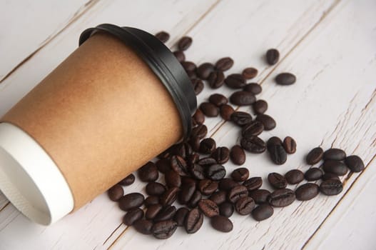 Takeaway coffee cup fall on coffee beans with customizable space for text or ideas. Copy space and coffee concept.