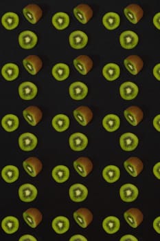 Pattern of kiwi. Top view of the sliced kiwi on black background. Minimal flat lay concept. Print