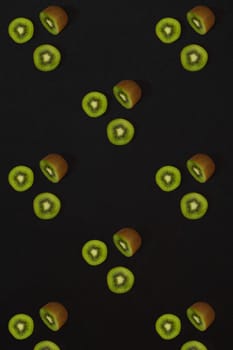 Pattern of kiwi. Top view of the sliced kiwi on black background. Minimal flat lay concept. Print