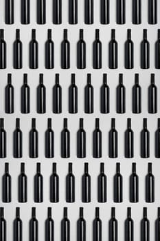 Dark wine bottles. Creative dark and textured abstract background. A lot of bottles of wine on a white background. Pattern