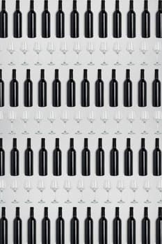 Dark wine bottles and glasses. Creative dark and textured abstract background. A lot of bottles of wine and glasses on a white background. Pattern