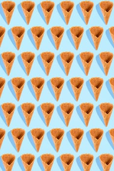 Sugar waffle cone for ice cream arranged in pattern on mint background. The image with copy space can be used as a background for the design of the confectionery menu, cards, greetings, invitations, pattern