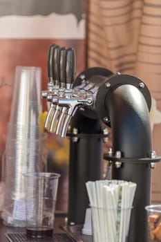 Handmade beer faucet. Bar counter in a pub with a beer tap, side view. The concept of buying, selling and drinking beer. High quality photo