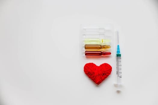 Medical colorful vials for injection syringe and red heart on a white background. Healthy heart.