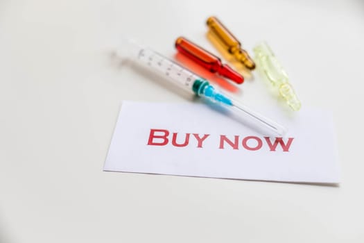 Pills and syringe. Pills and syringe on red background. Copy space.Buy now poster, card. Internet shopping.