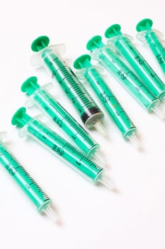 Syringes scattered on a gray background close up