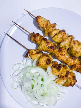 Traditional delicious turkey or chicken shish kebab skewer barbecue meat with tomatoes, pepper and sauce. Served on white kitchen table background. Natural light. Picnic bbq gourmet.