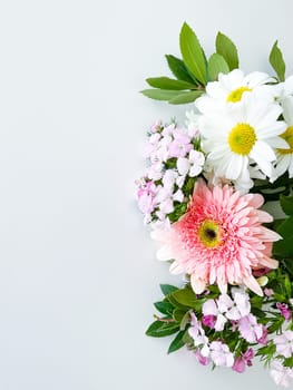 japanese dianthus, gerbera, chamomile, matthiola and laurel leaves. floral frame with empty space for text or inscription. spring postcard