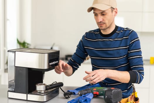 professional young worker fixing coffee machine.