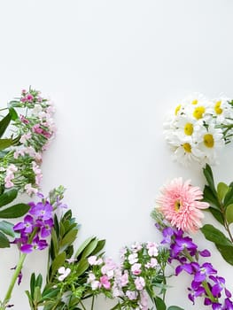 japanese dianthus, gerbera, chamomile, matthiola and laurel leaves. floral frame with empty space for text or inscription. spring postcard