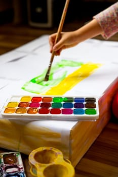 Little girl painting in her nursery at home